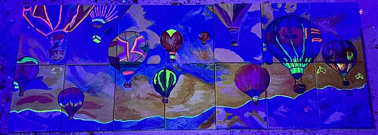 'The Sky is the Limit': A puzzle image showing hot air balloons on the sky. The picture is decided in 7 columns and two rows. The parts don't perfectly match. The Picture is illuminated under black light, and some highlights are fluorescent.