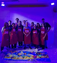 The research group behind the collaborative picture lying on the floor with black light on