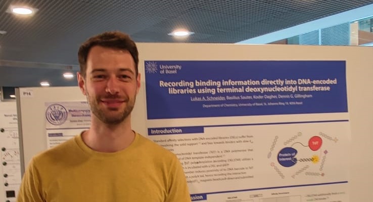 Dr. Lukas Schneider in front of his poster.